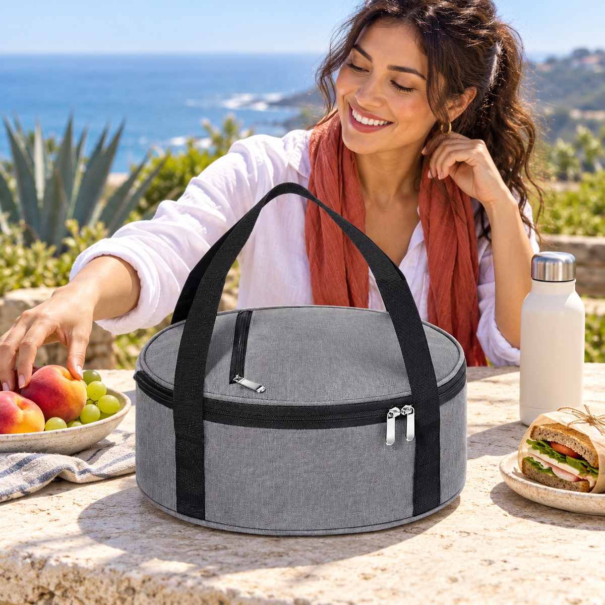 Gray round lunch bag at a coastal picnic table